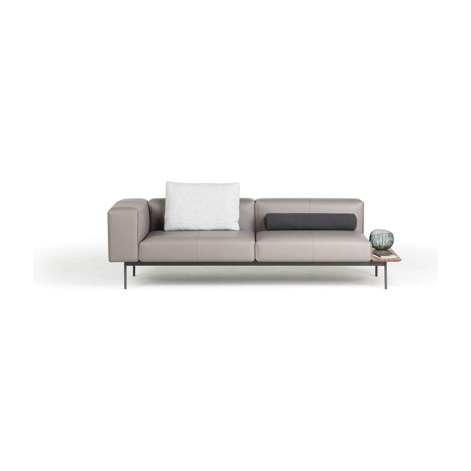 Convert Sofa als 3-Sitzer in taupefarbenem Leder, frontale Ansicht mit linker Armlehne, dunkler Nackenrolle und seitlich angesetzter Ablage aus Holz.