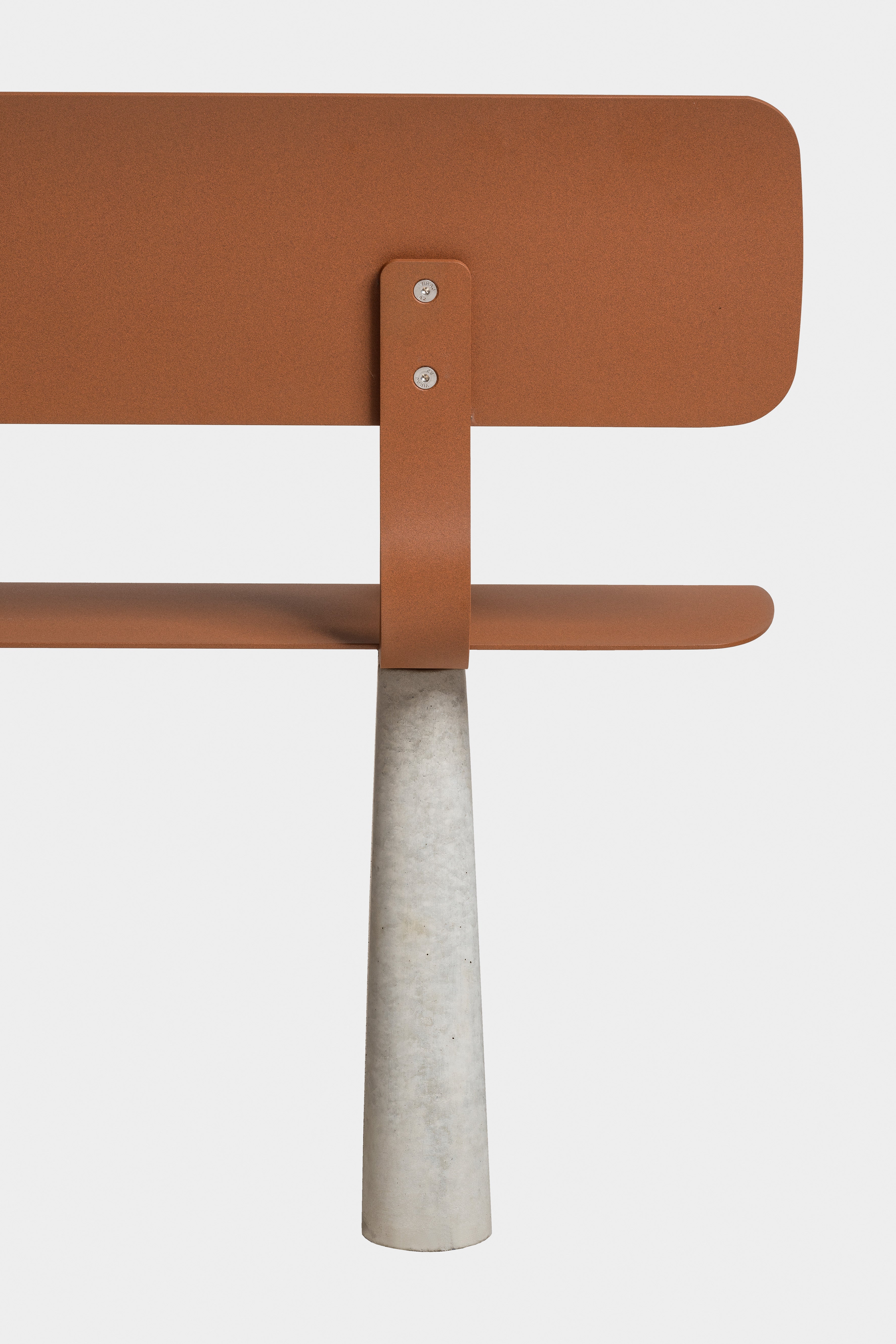 Ben – Bank – Rückenlehne eines Stuhls in rostfarbener Metalloptik mit betonsäulenförmigem Fuß.