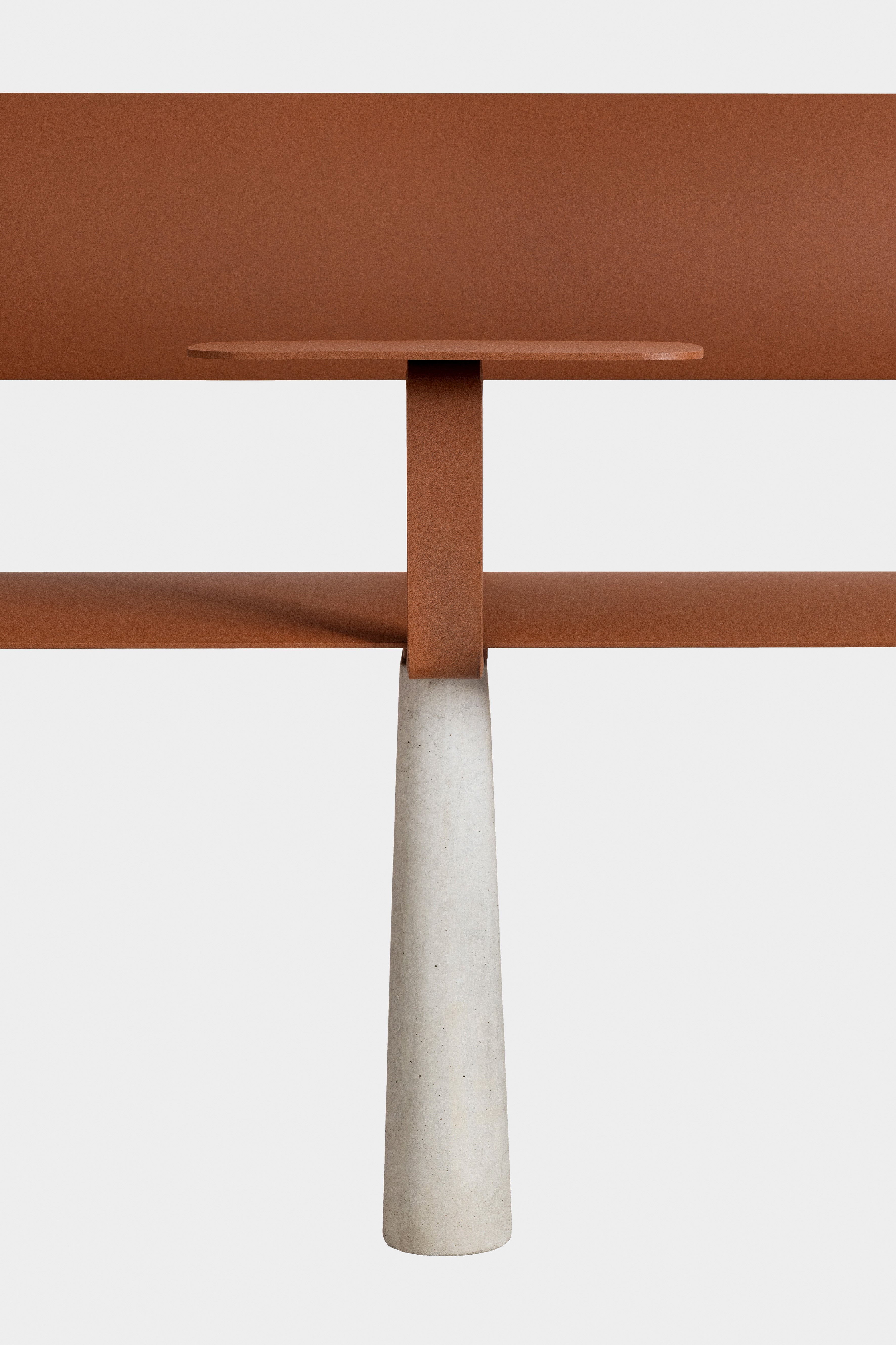 Ben – Bank – Minimalistische Tischoberfläche in Rostfarbe mit einem stabilen, grauen Betonsäulenfuß in der Mitte.