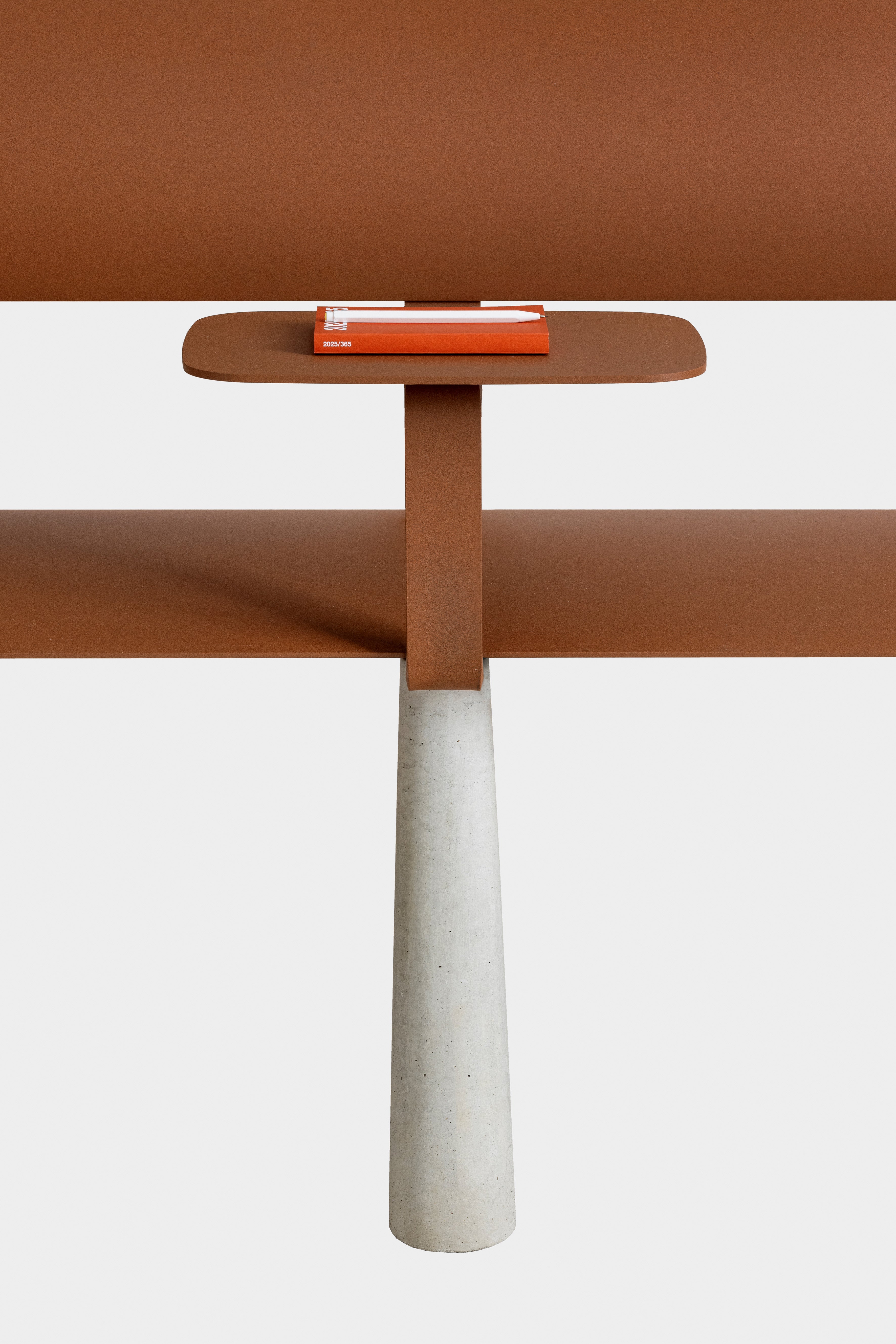 Ben – Bank – Tisch mit braunem Tischblatt und grauem Betonsockel; darauf liegt ein rotes Notizbuch.