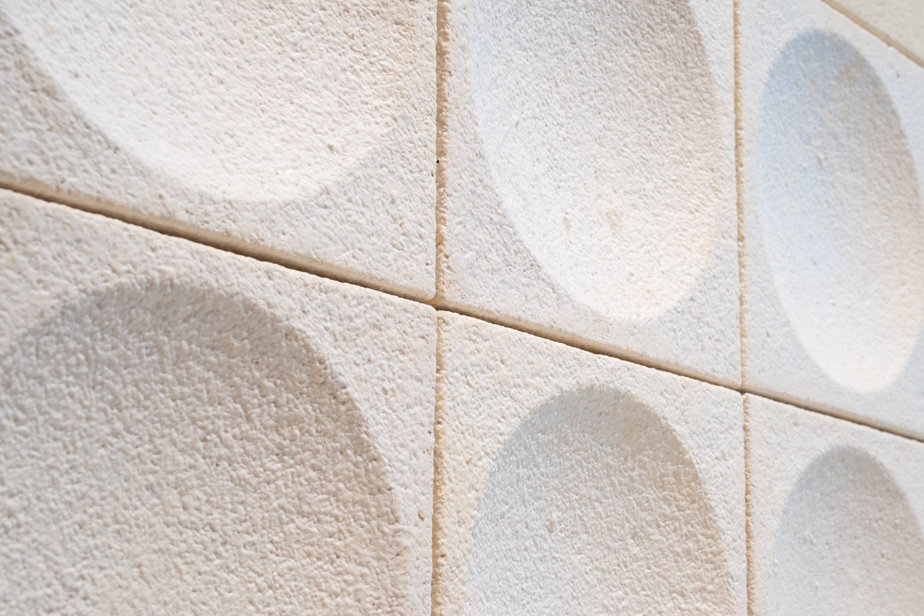 Archisonic Mycelium Wandfliesen – Akustische Wandverkleidung – Wandverkleidung mit strukturiertem Muster aus hellen, runden Elementen auf einem neutralen Hintergrund.