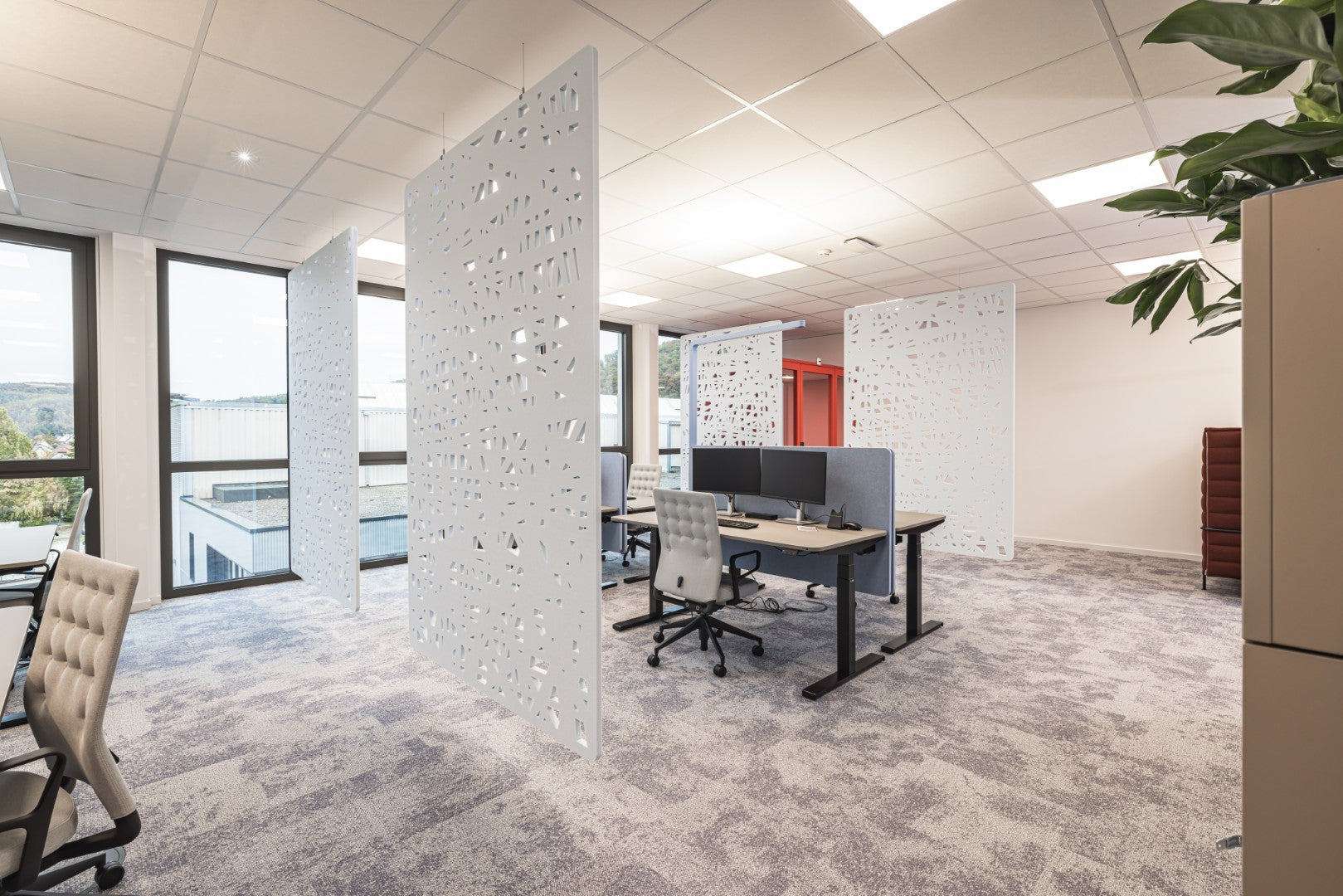 Arbeitsplatztrenner Infra – Akustische Tischtrenner – Moderne Büroumgebung mit zwei Schreibtischen, akustischen Trennwänden und ergonomischen Bürostühlen. Hochwertiger Teppichboden.