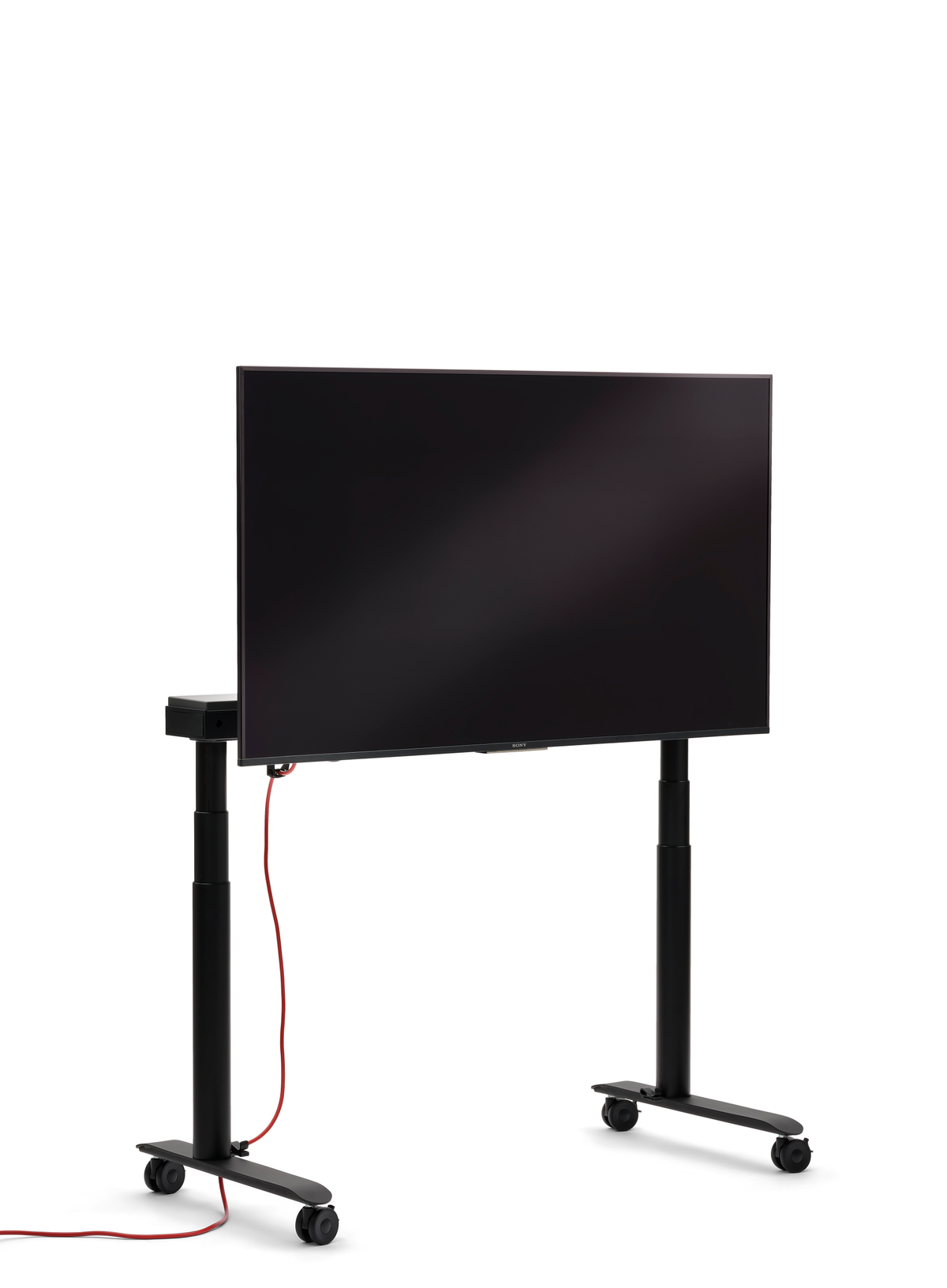 se:lab monitor caddy – Monitor Caddy – Stehender Fernseher auf einem mobilen Gestell mit vier Rollen, schwarzer Rahmen und rotem Kabel.