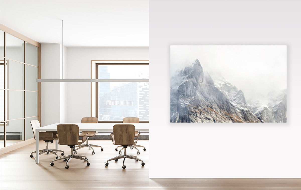 Dezibel Print – Wandabsorber – Konferenzraum mit einem Holztisch und drehbaren Stühlen. An der Wand hängt ein Bergmotiv.