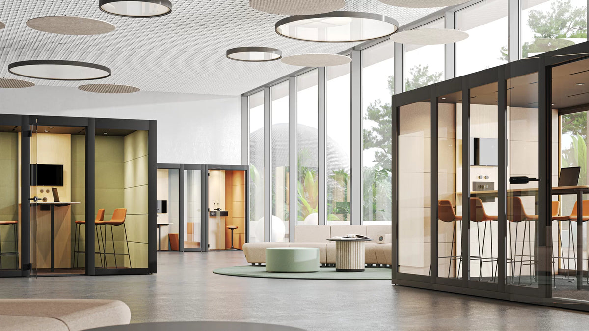 Silent Room XL | Meetingbox – Meetingbox – Moderne Büroumgebung mit Glaskabinen, gemütlichen Sitzmöbeln und schallabsorbierenden Deckenpanelen.