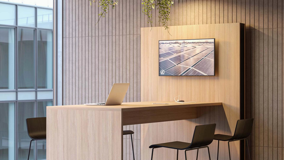 Media – Konferenzwand – Holztisch mit Laptop und Stühlen in modernem Büro, Holzpaneele im Hintergrund, Bildschirm mit Solarmodulen.