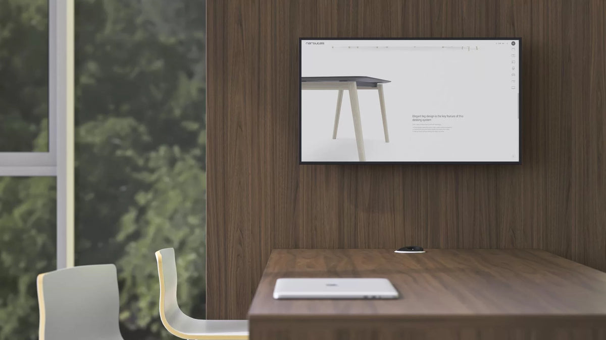 Media – Konferenzwand – Ein moderner Schreibtisch mit Holzoberfläche und hellen Beinen, im Hintergrund ein Bildschirm mit Produktinformationen.