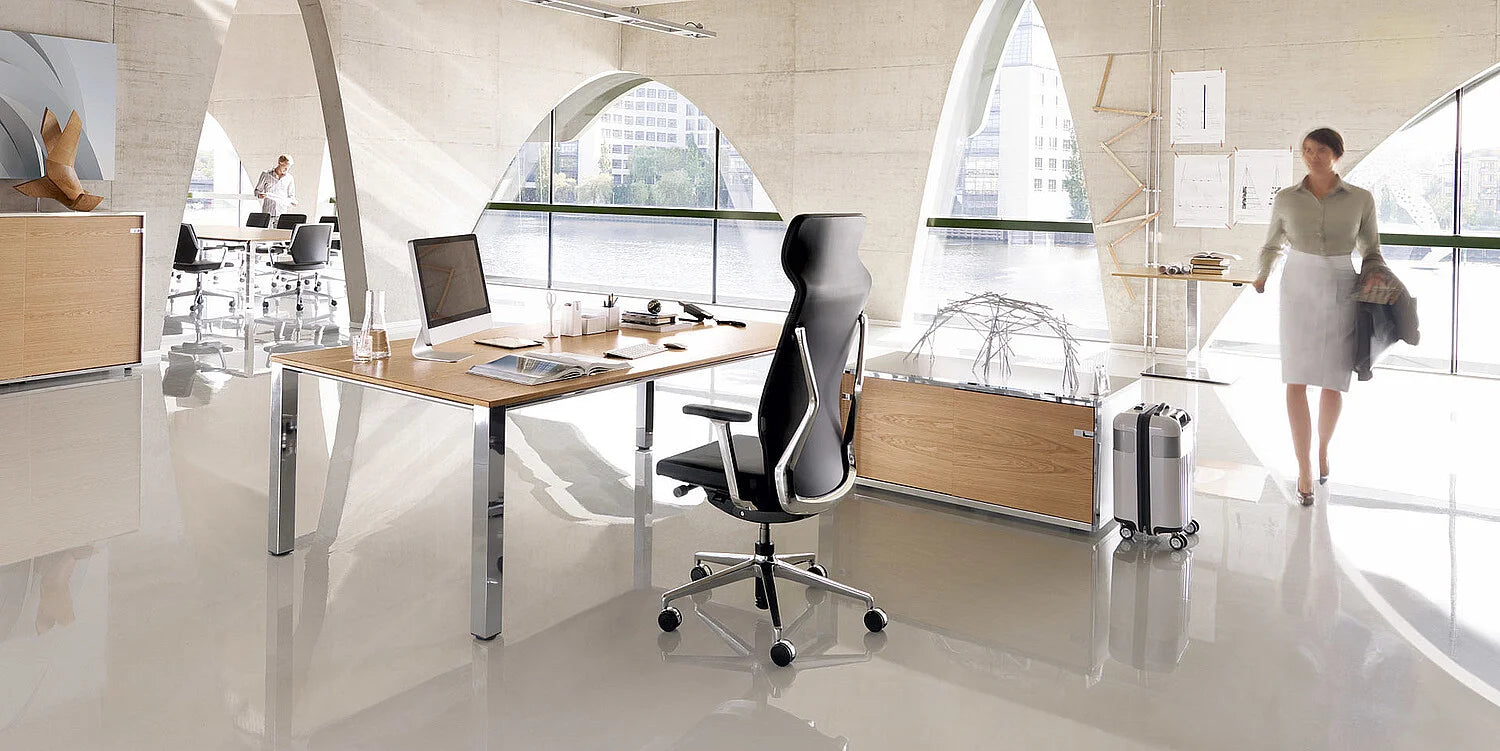 crossline – ergonomischer Bürostuhl – Moderner Schreibtisch aus Holz mit Metallgestell, schwarzer Bürostuhl, Fenster mit Blick auf den Fluss, ansprechende Büroumgebung.
