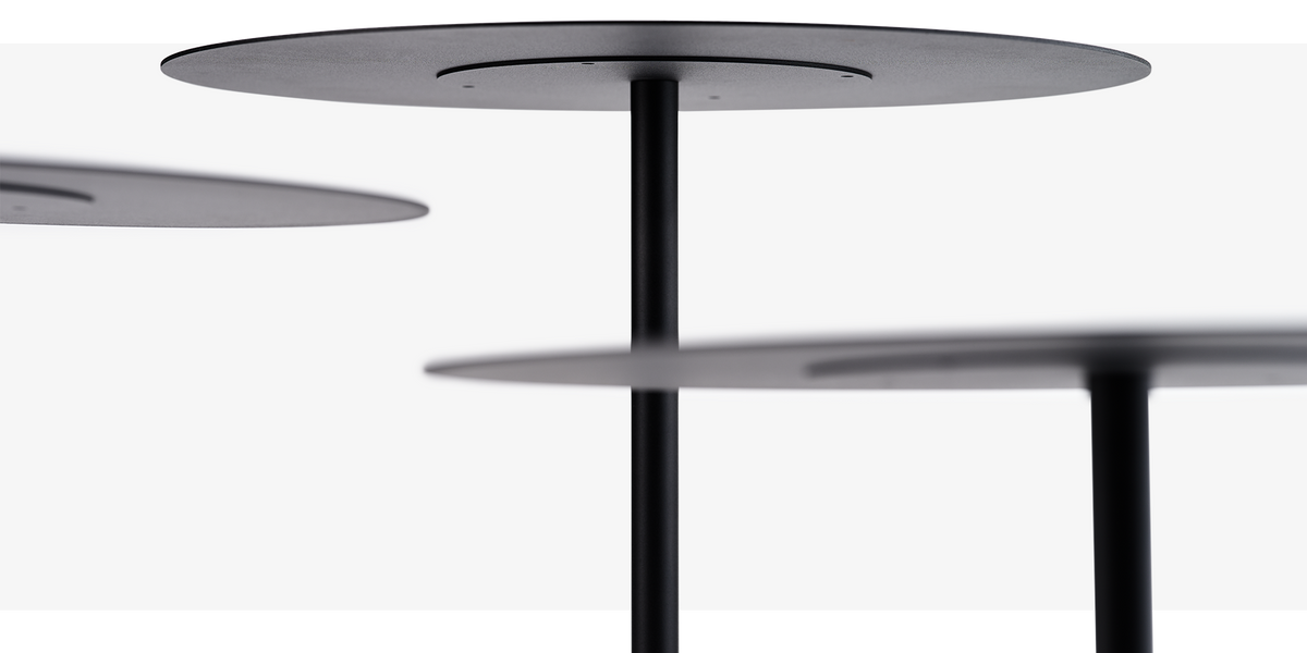 se:tea – Beistelltisch – Drei schwarze Tischplatten mit einem zentralen, runden Fuss aus Metall, vor einem neutralen Hintergrund.