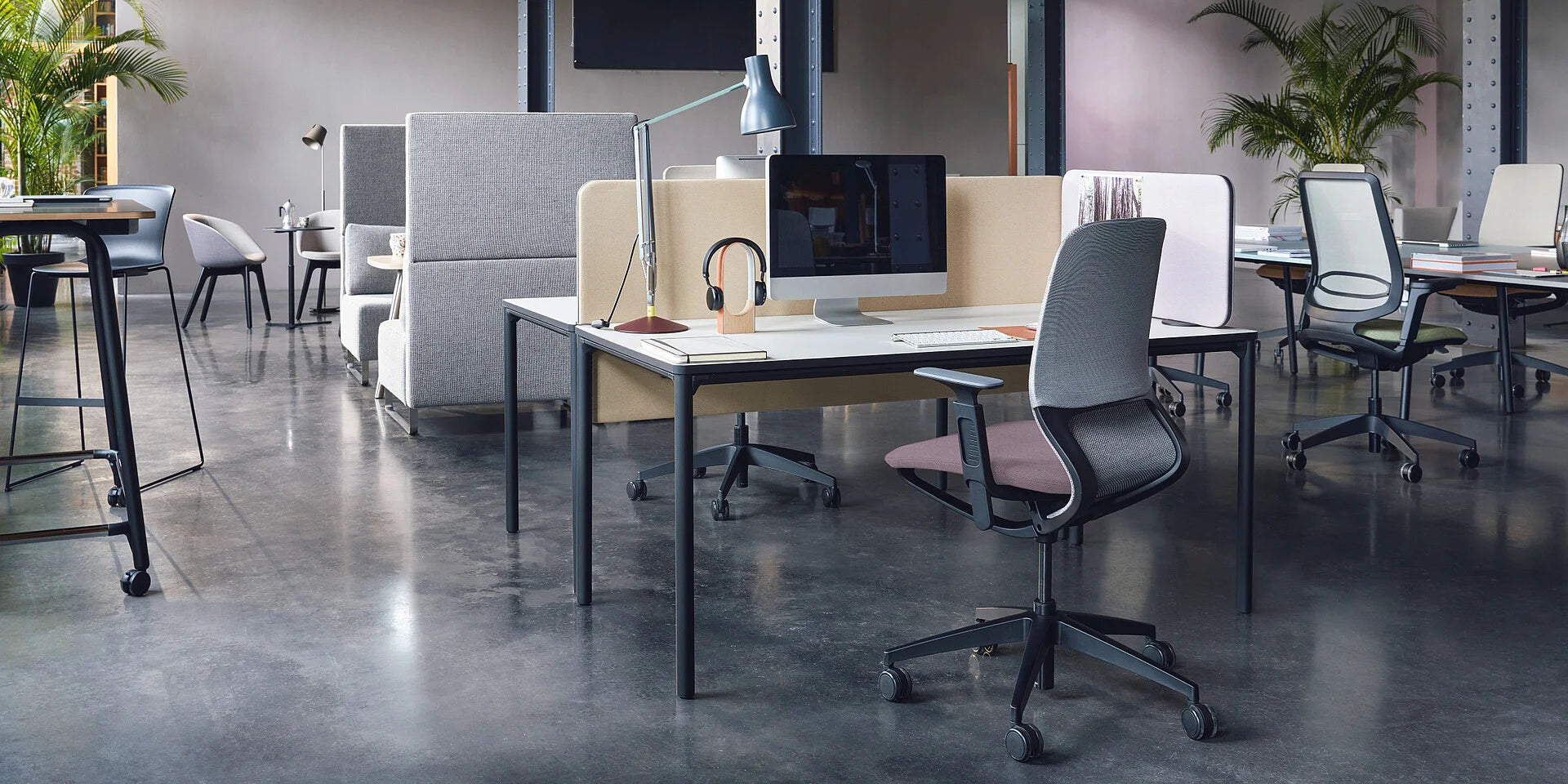 easy screen silent – Schreibtischaufsatzelement – Moderner Arbeitsplatz mit Schreibtisch, Bürostuhl in Grau, Computer und Lampe, umgeben von Trennwänden und Pflanzen.