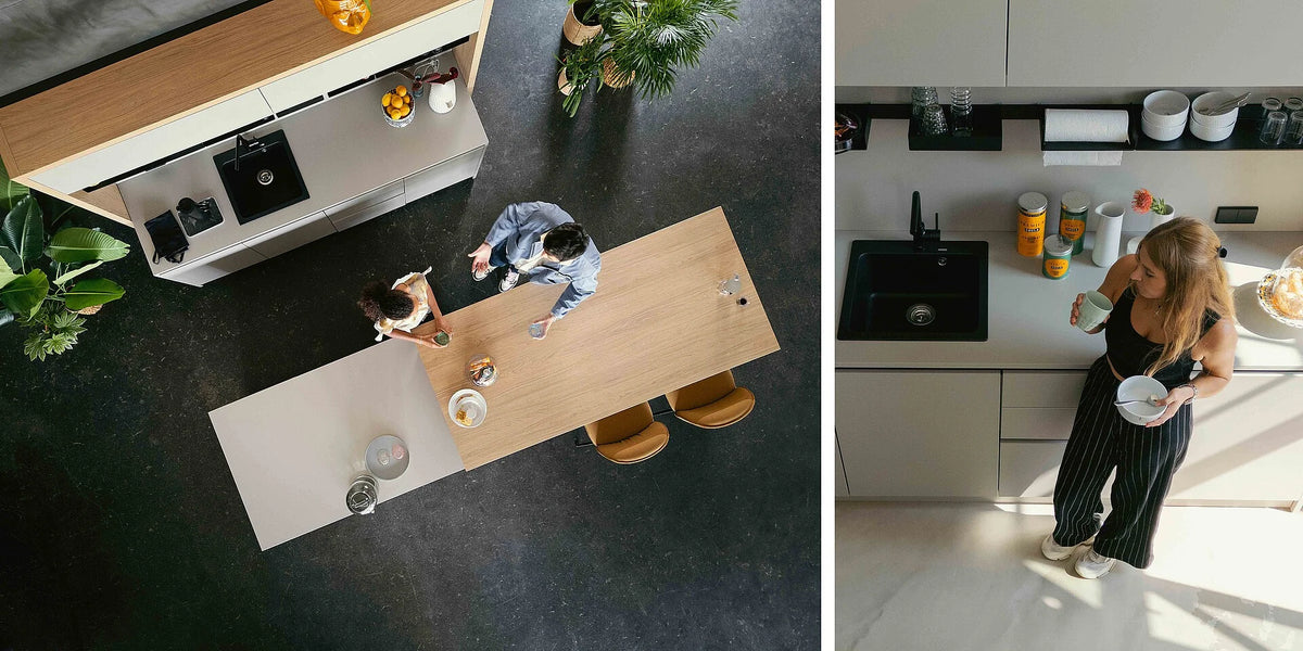 se:café bar – Bar – Moderne Küche mit Holz- und Grautönen, zwei Personen an einem grossen Tisch, Pflanzen im Raum.