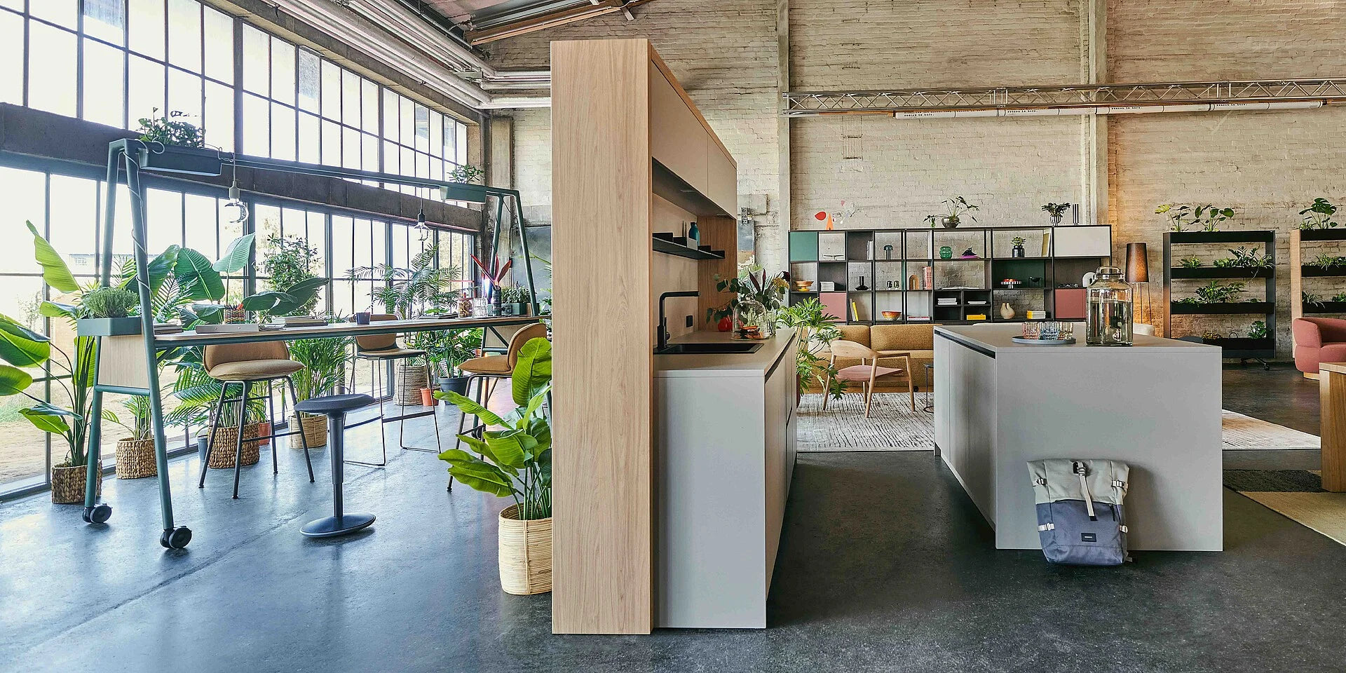 se:café bar – Bar – Moderne Büroeinrichtung mit Holzregal, Tisch, Stühlen und Pflanzen in einem hellen Raum mit grossen Fenstern.