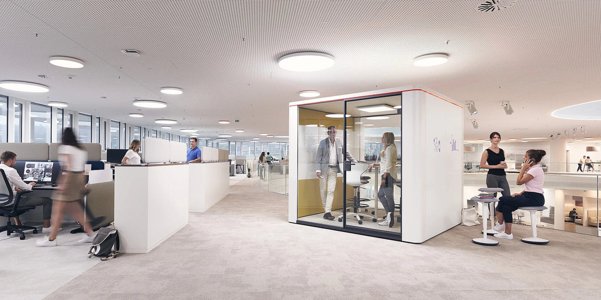 se:cube S – Telefonbox – Modernes Büro mit Akustikkabine, Schreibtischen und Stühlen. Personen in Gesprächen und Arbeit an Computern.