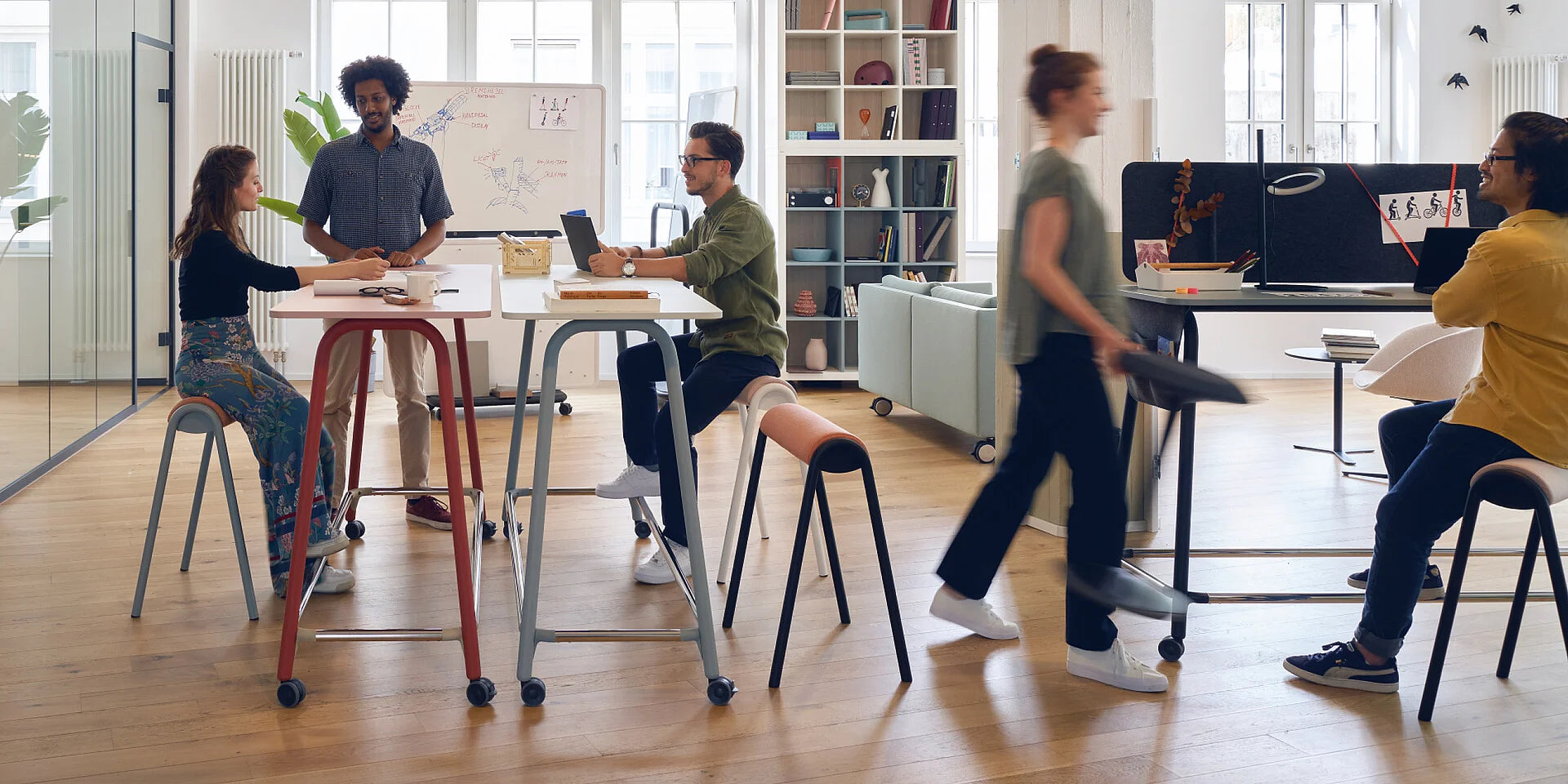 se:lab high desk – Hochtisch – Offene Bürolandschaft mit mehreren Stehtischen und Barhockern. Personen in Interaktion, helle Holzboden und große Fenster.
