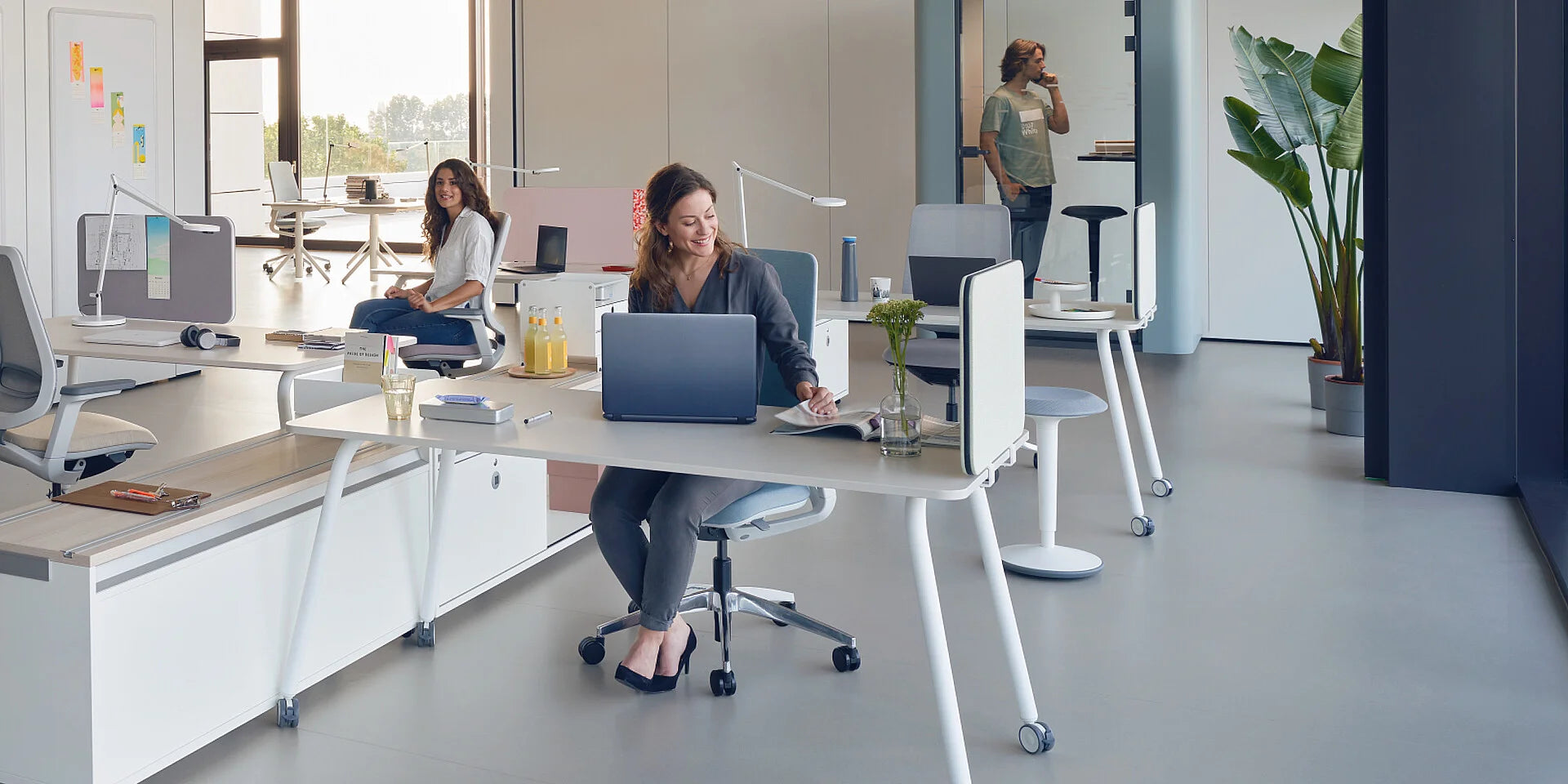 se:lab work desk – Schreibtisch – Moderne Büroumgebung mit Schreibtisch, Bürostuhl und Pflanzen. Zwei Personen arbeiten am Schreibtisch.