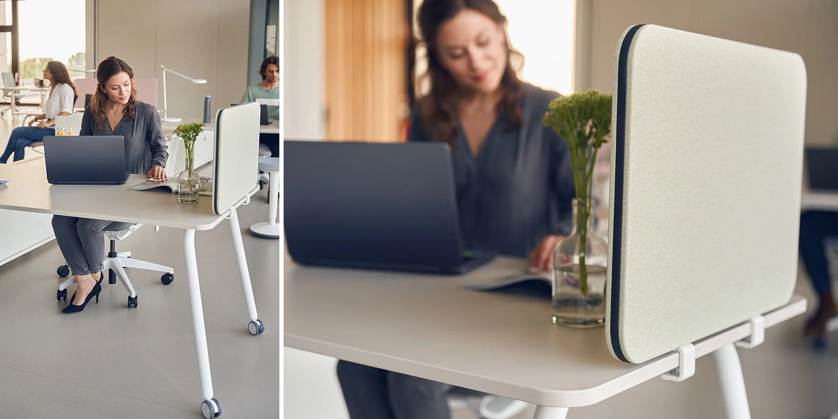 se:lab work desk – Schreibtisch – Modernen Schreibtisch mit hellen, runden Beinen. Person sitzt daran und arbeitet am Laptop, Pflanze auf dem Tisch.