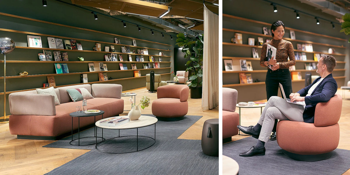 se:living – Loungetisch – Gemütliche Lounge-Ecke mit rosa und hellbeigen Sofas, runden Tischen und Teppich in moderner Umgebung. Bücherregal im Hintergrund.