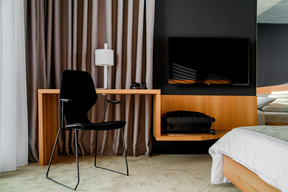 Oblikant Stuhl von Prostoria in Schwarz an einem Sideboard im Hotelzimmer. © Prostoria