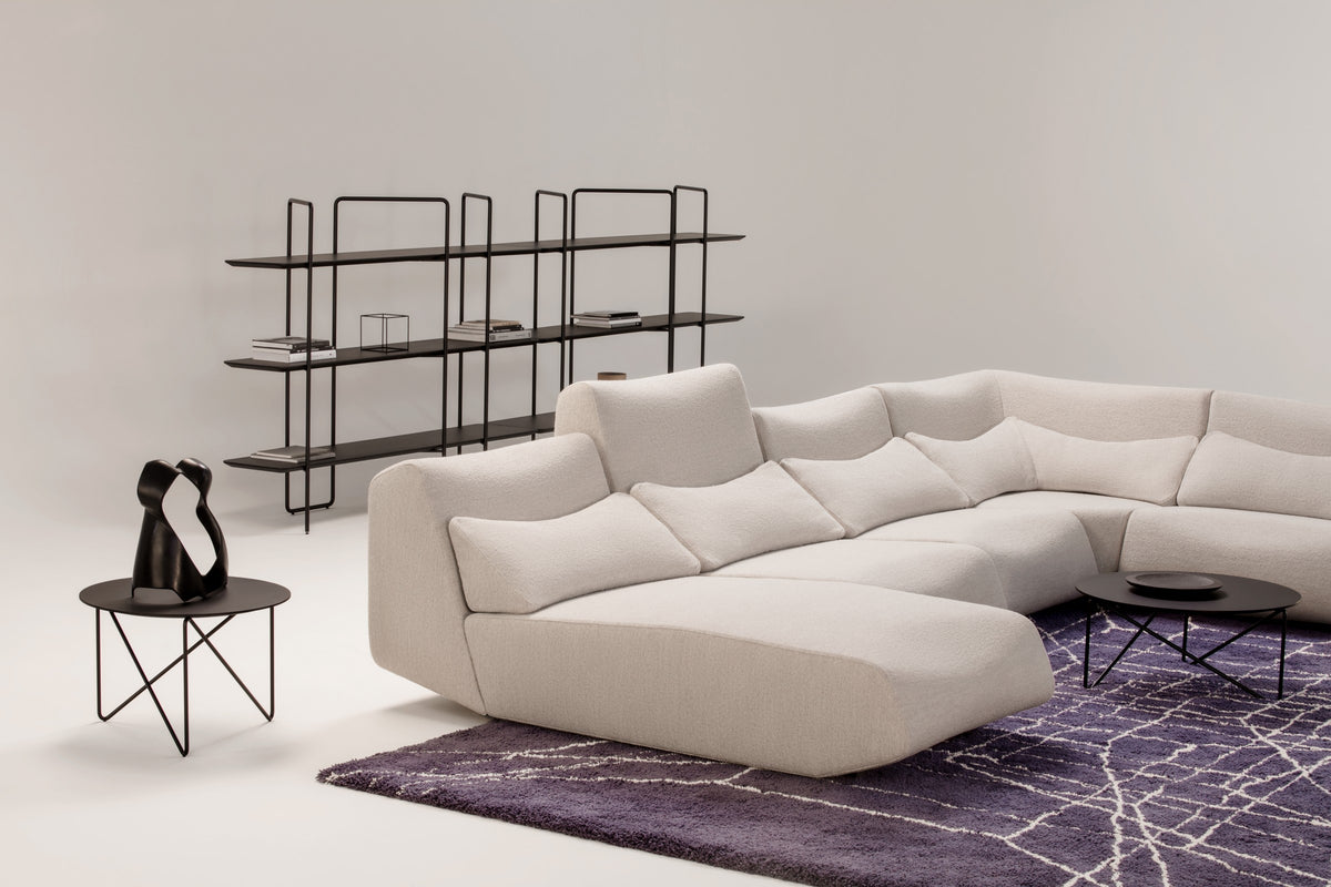 Absent Sofa von Prostoria in Hellbeige vor einem Regalsystem. © Prostoria