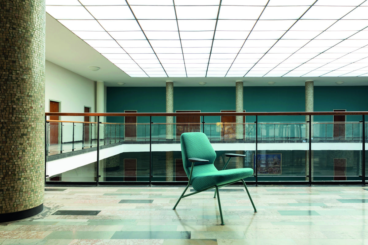Oblique Loungesessel von Prostoria in Grün in einer Halle mit Galerie. © Prostoria