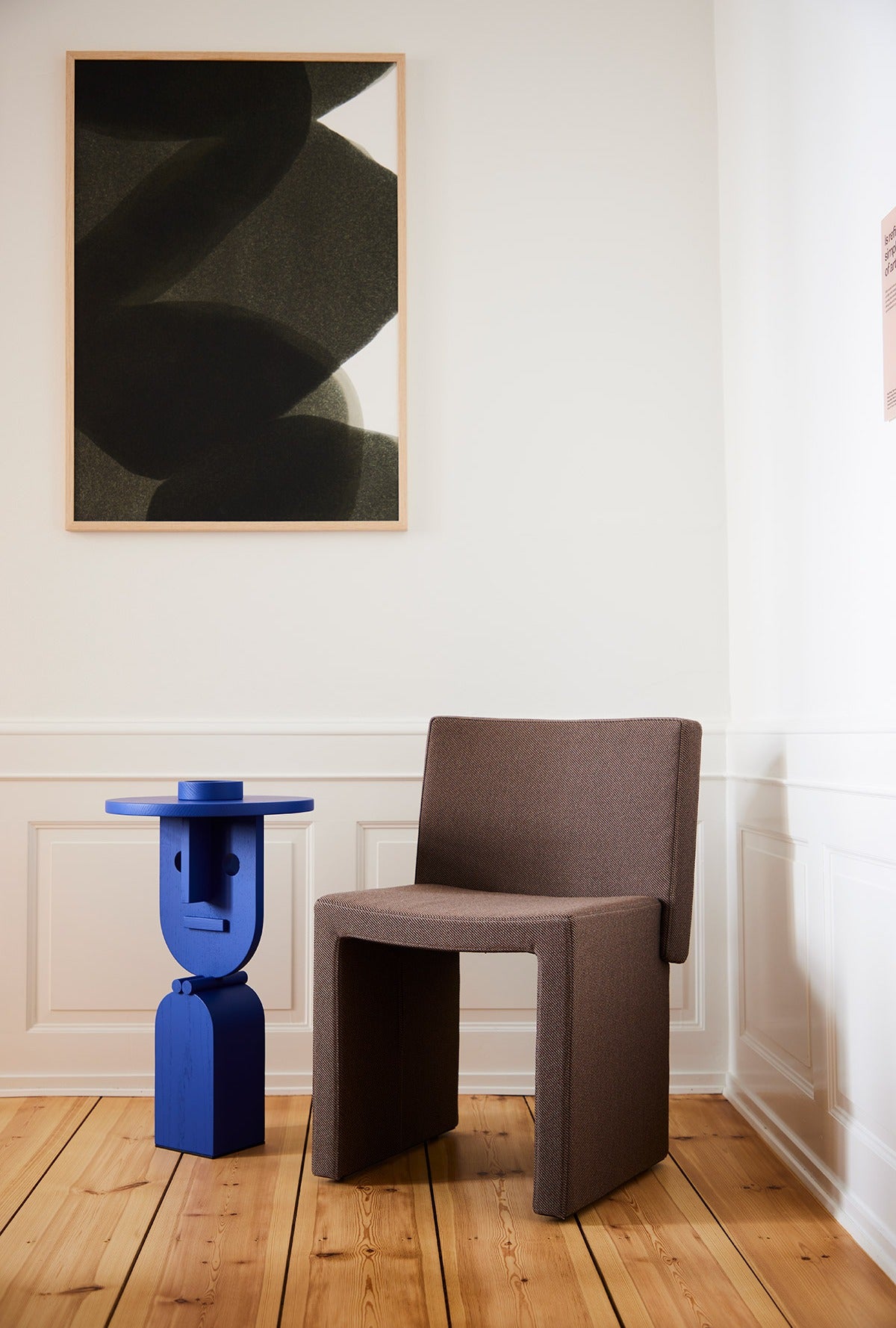 Sancal Cita Stuhl in Braun neben einem blauen Beistelltisch auf Holzdielen