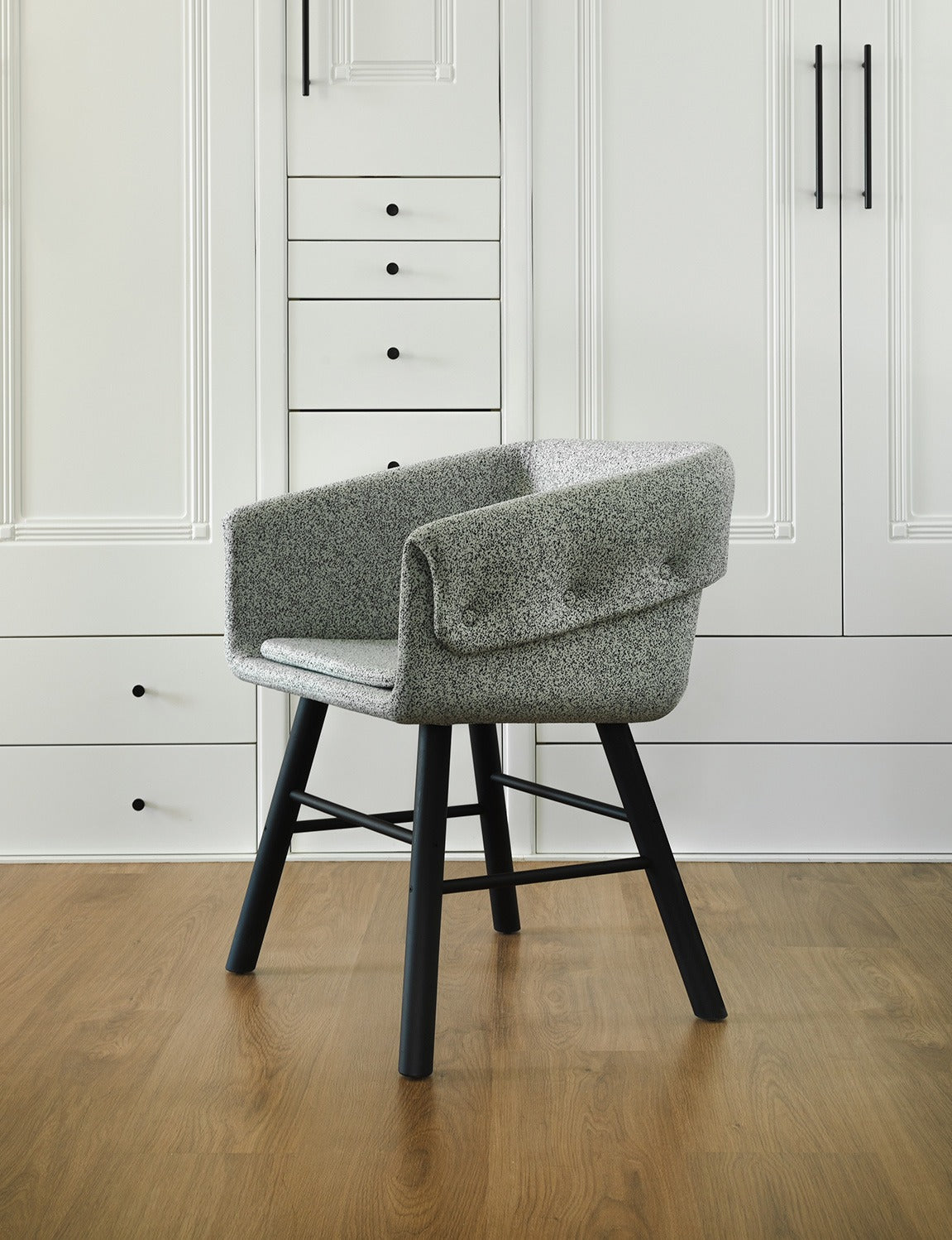 Sancal Collar Stuhl mit meliertem Bezug in Grau und schwarzen Holzbeinen vor einem Einbauschrank