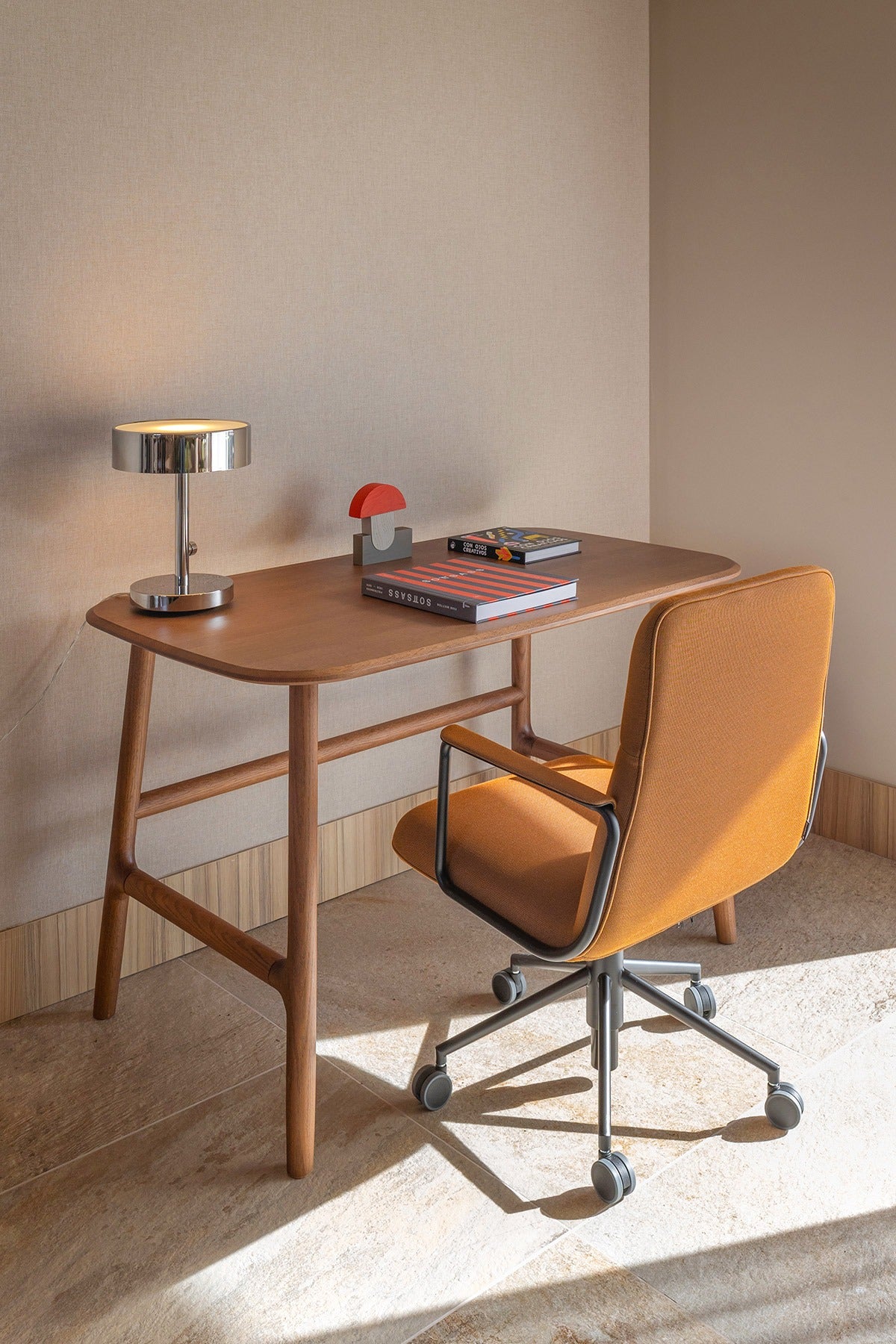 Sancal Elle Konferenzstuhl in Orangebraun mit Armlehnen und Rollen an einem Holzschreibtisch