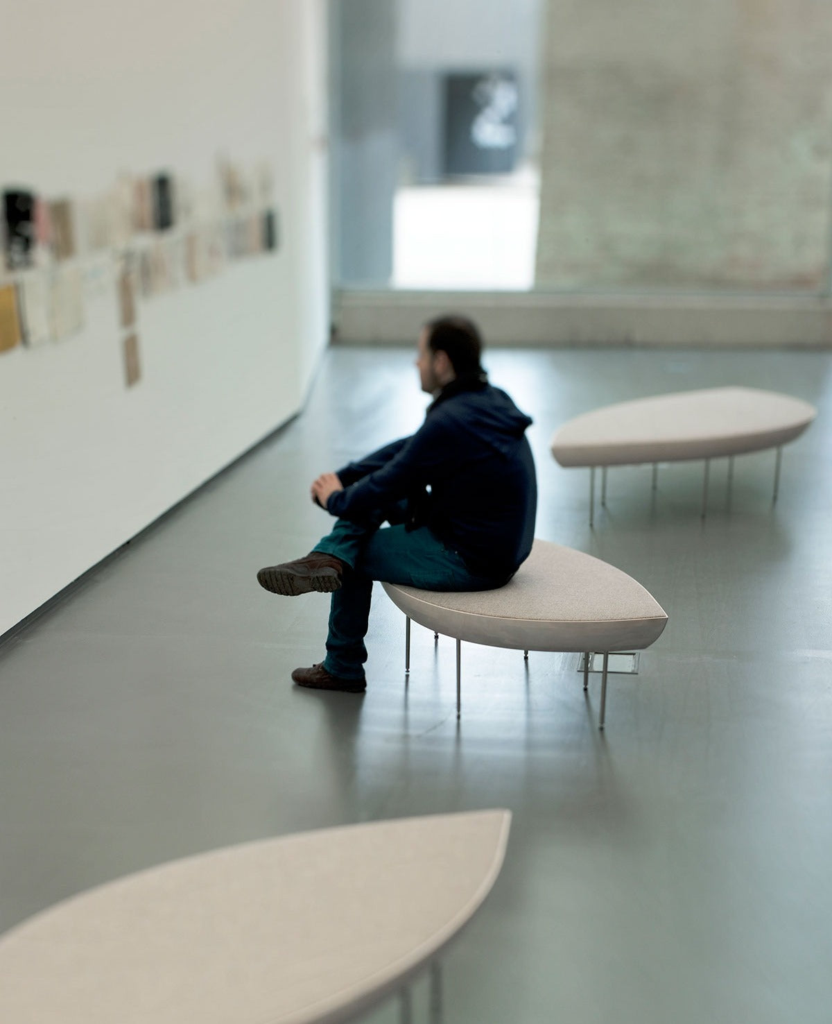 Sancal Konoha Bank in einer Ausstellungshalle mit sitzendem Besucher