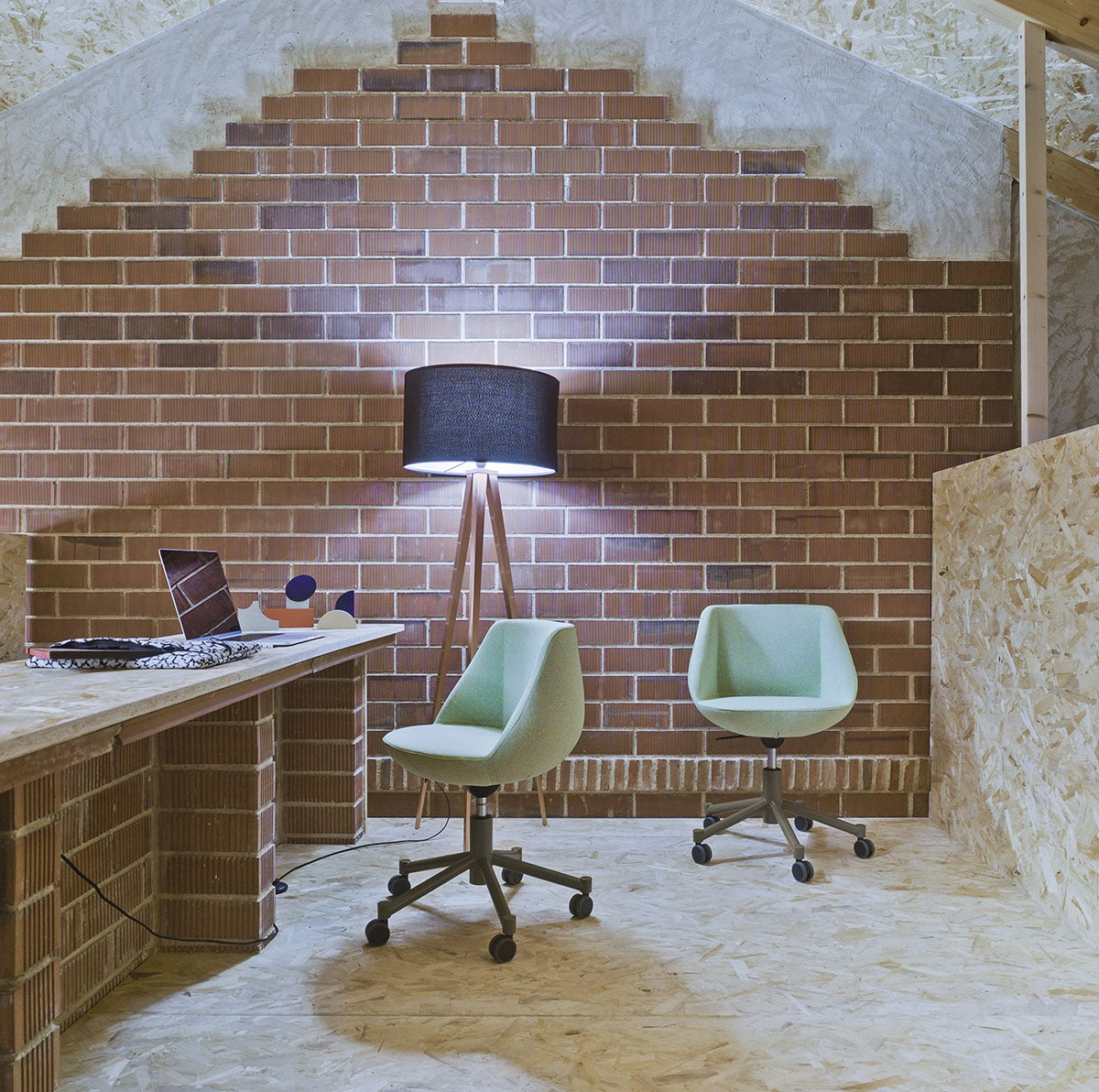 Zwei Sancal Magnum Konferenzstühle auf Rollen an einem Arbeitsplatz vor einer Ziegelwand
