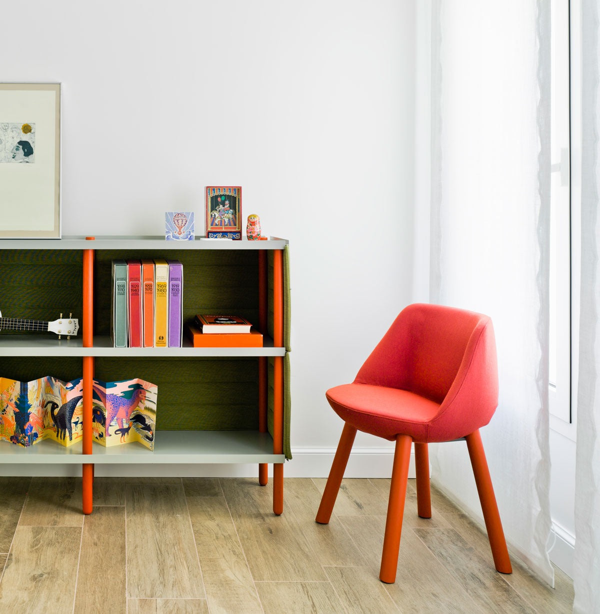 Sancal Magnum Stuhl in Rot mit Holzbeinen vor einem Regal