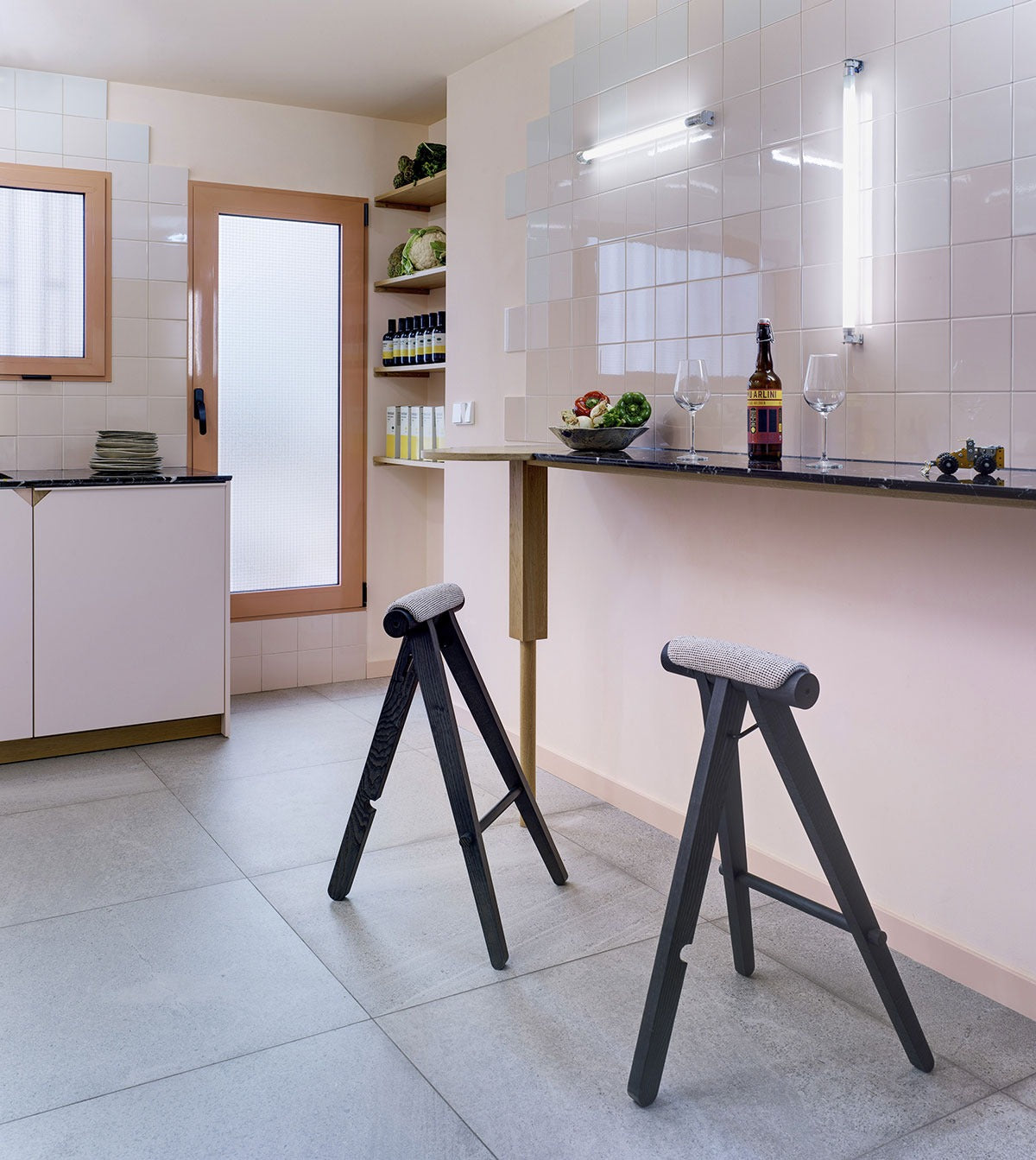 Zwei Sancal Perigallo Hocker in Schwarz mit hellgrauem Sitz an einer Theke in einer Küche mit rosa Wänden