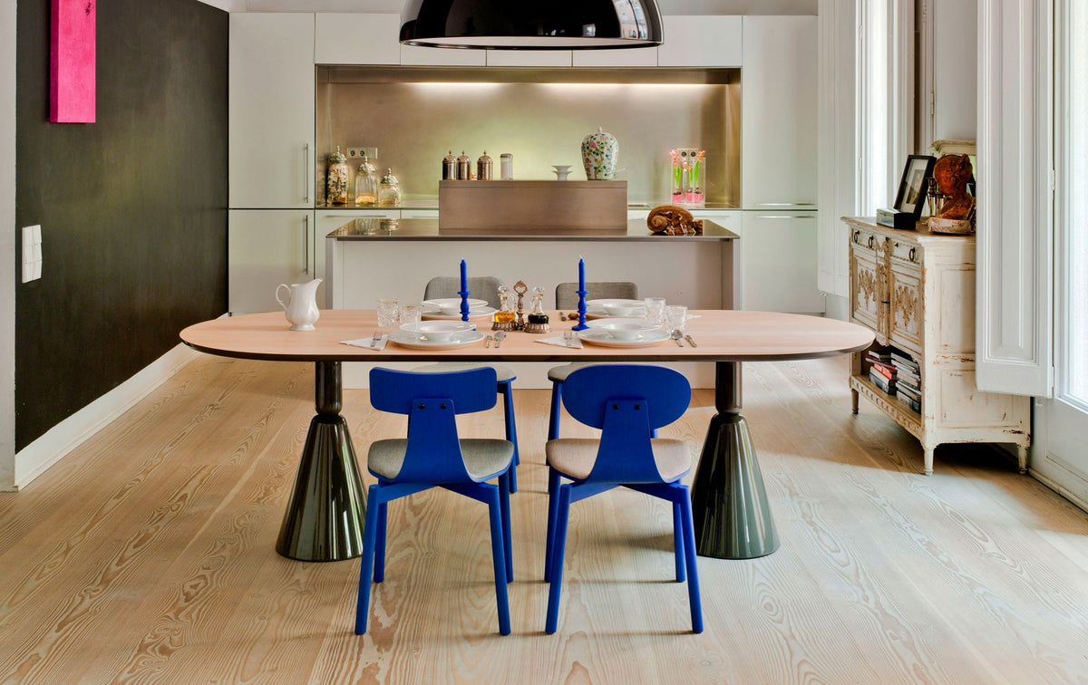 Sancal Silla40 Stühle in Blau mit rechteckigem und ovalem Rücken an einem ovalen Esstisch in einer Wohnküche