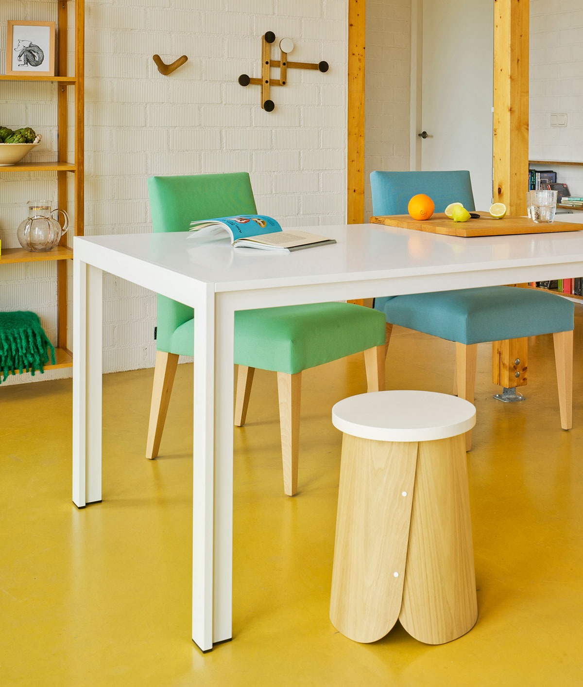 Sancal Tab Hocker mit weisser Sitzfläche an einem Esstisch in einer Küche mit gelbem Boden