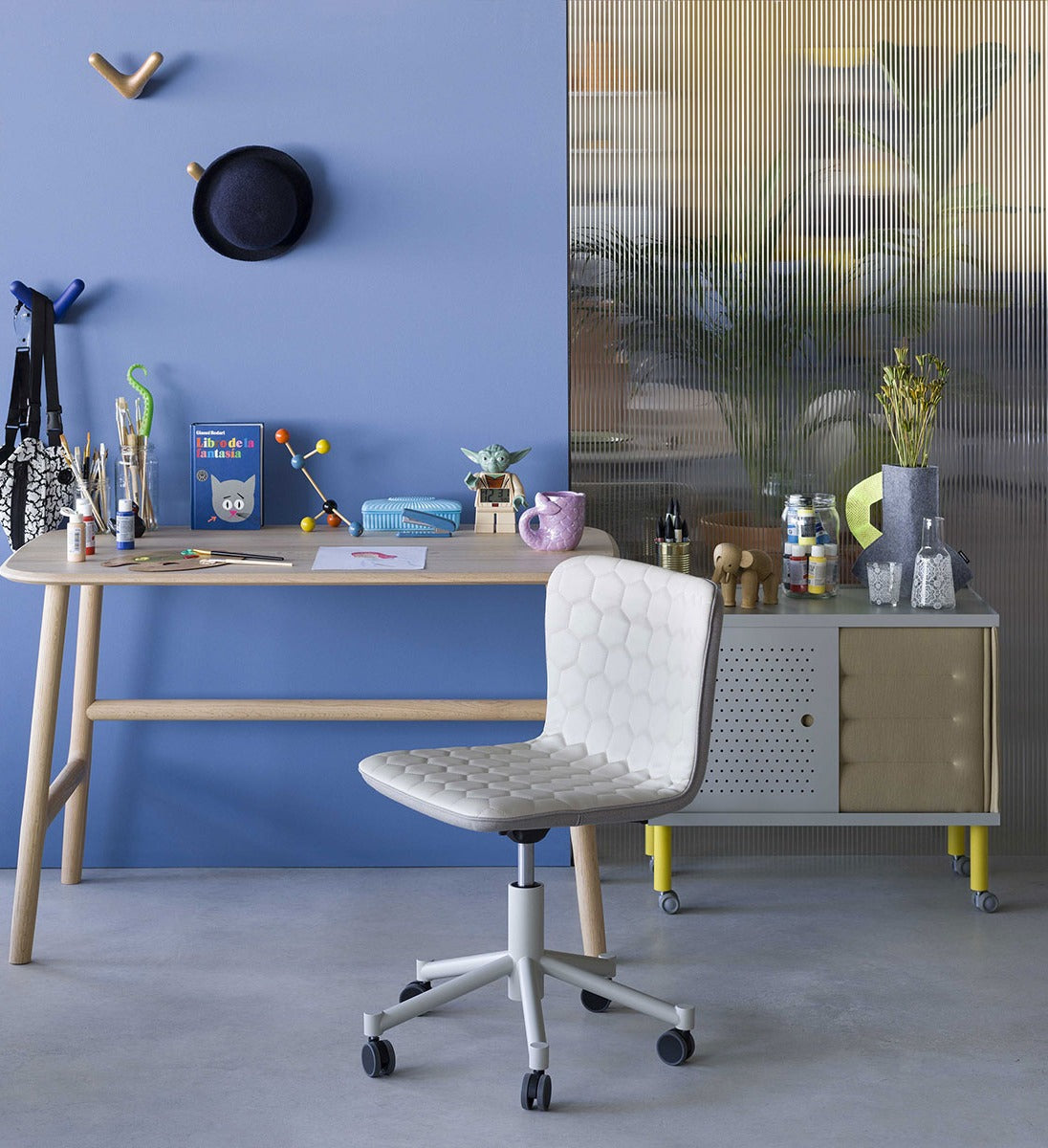 Sancal Tea Konferenzstuhl in Weiss an einem Schreibtisch vor einer blauen Wand