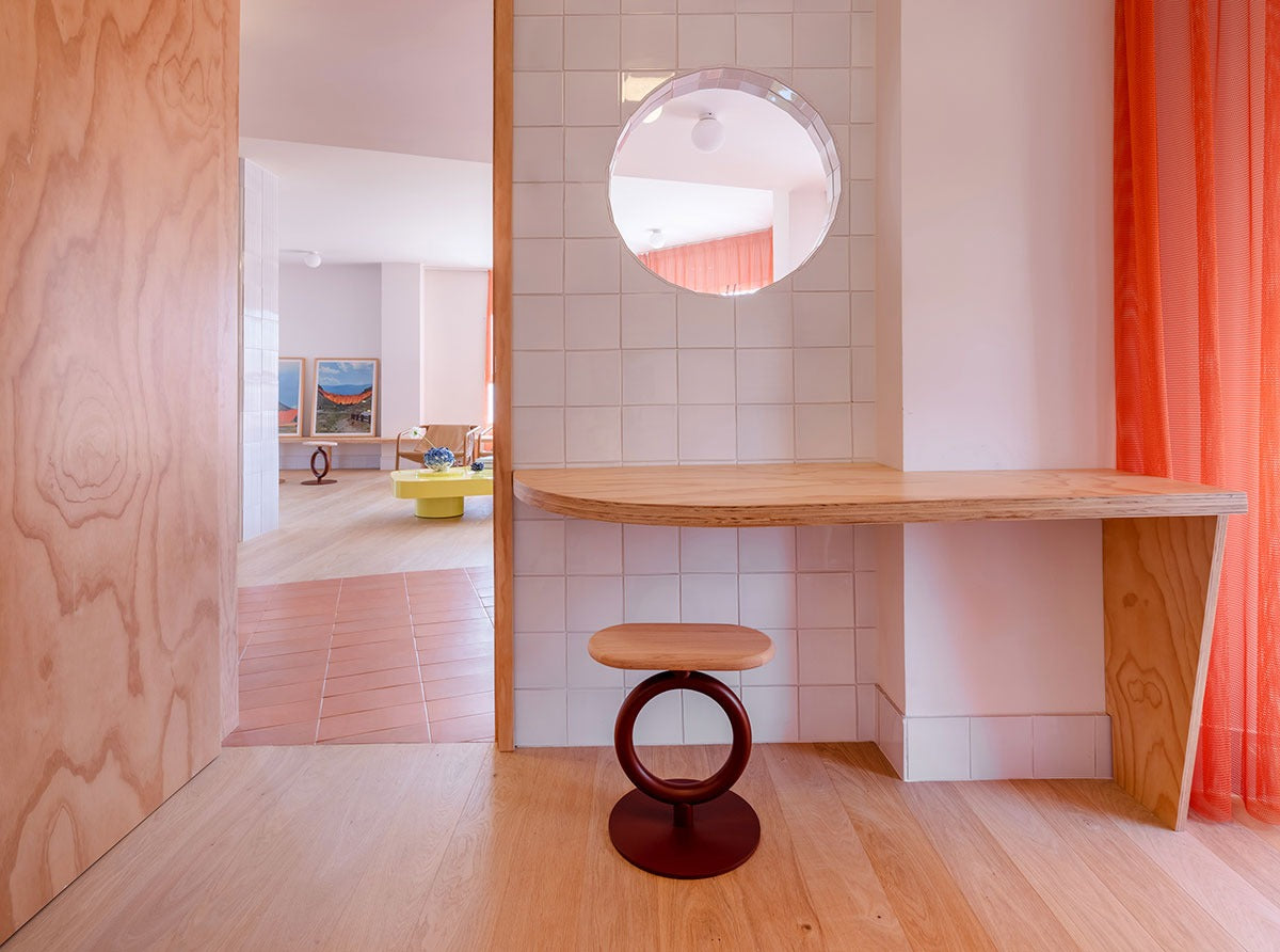 Niedriger Sancal Totem Hocker mit Holzsitz unter einer Wandkonsole in einem rosa Raum