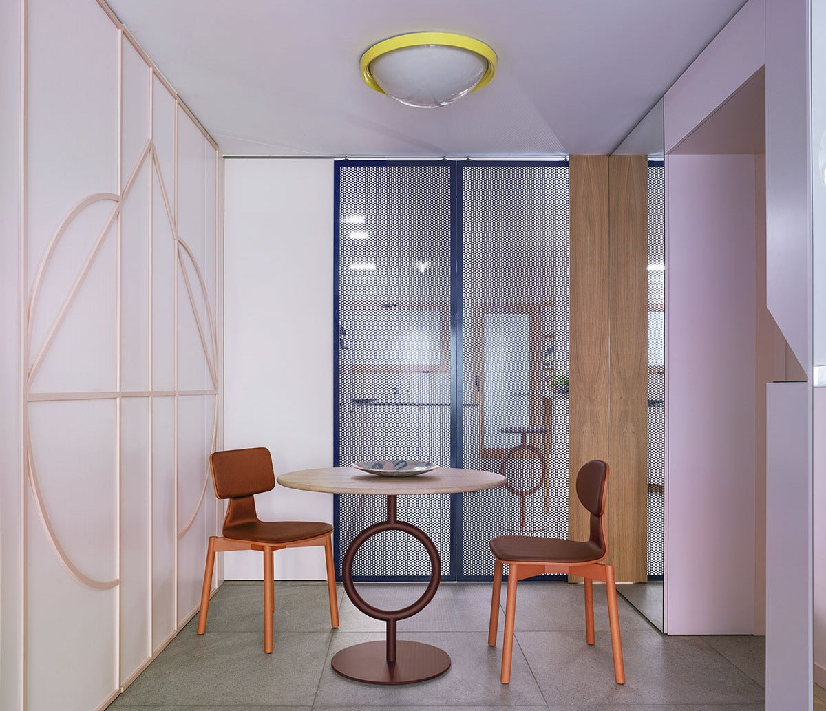 Sancal Totem Tisch rund mit Ringgestell in Terrakotta und zwei Stühlen in einem rosa Raum