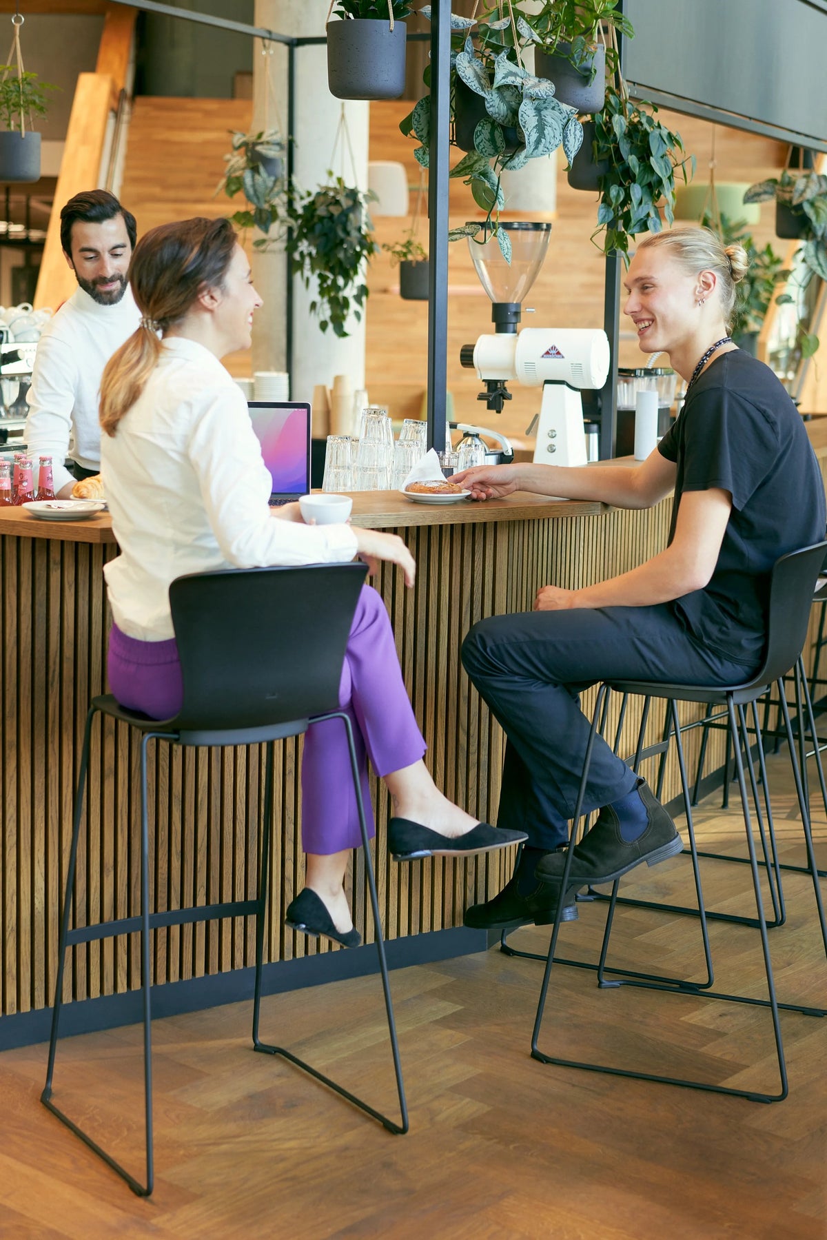 se:spot stool von Sedus mit Kufengestell an einer Theke, zwei Personen im Gespräch.