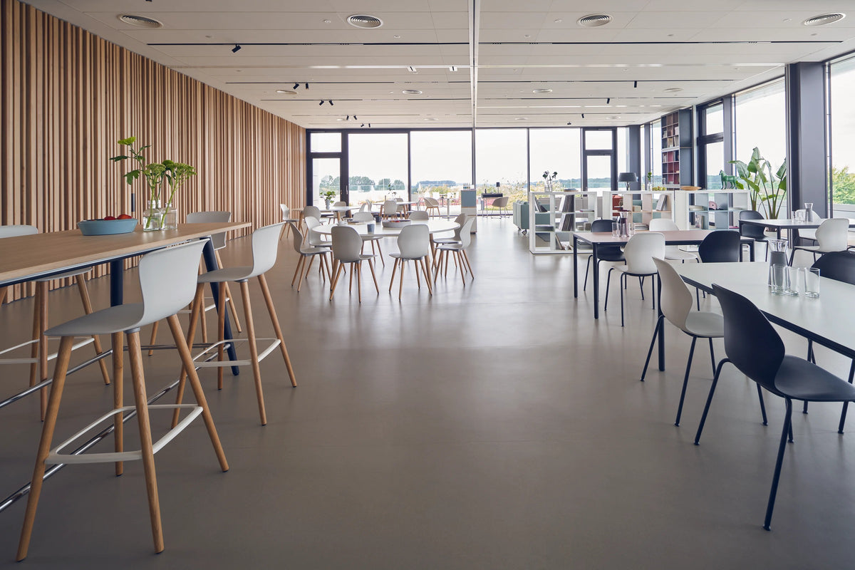 se:spot stool von Sedus mit Holzgestell in einer Cafeteria, Blick in den Raum.