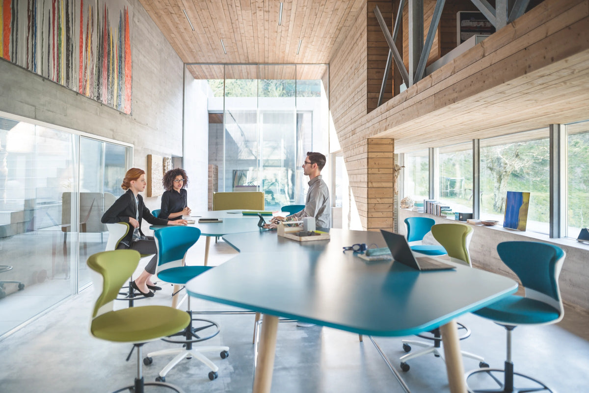 mastermind high desk – Hochtisch von Sedus – Blauer Hochtisch mit Hockern, Team im Gespräch.