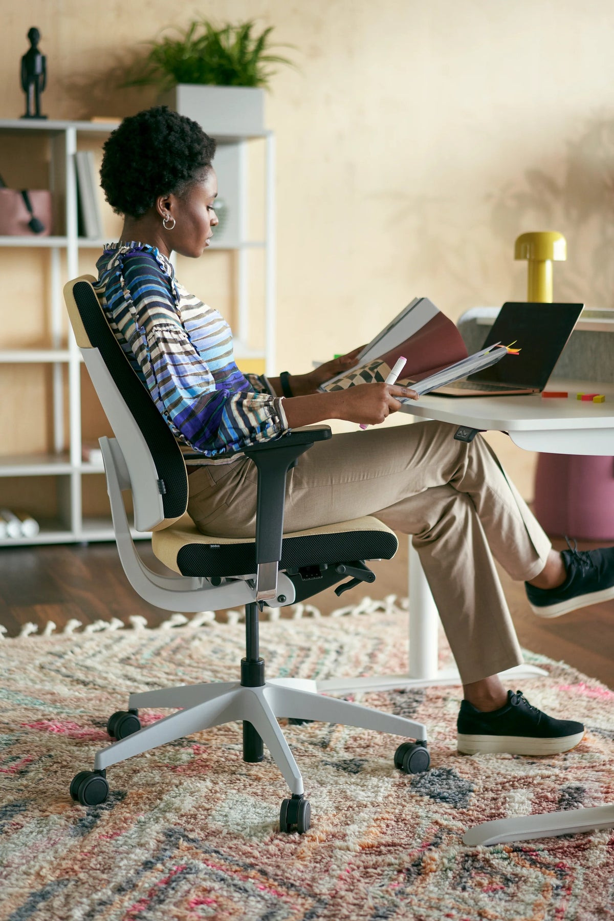 black dot Bürodrehstuhl von Sedus, Person liest zurückgelehnt am Homeoffice-Platz.