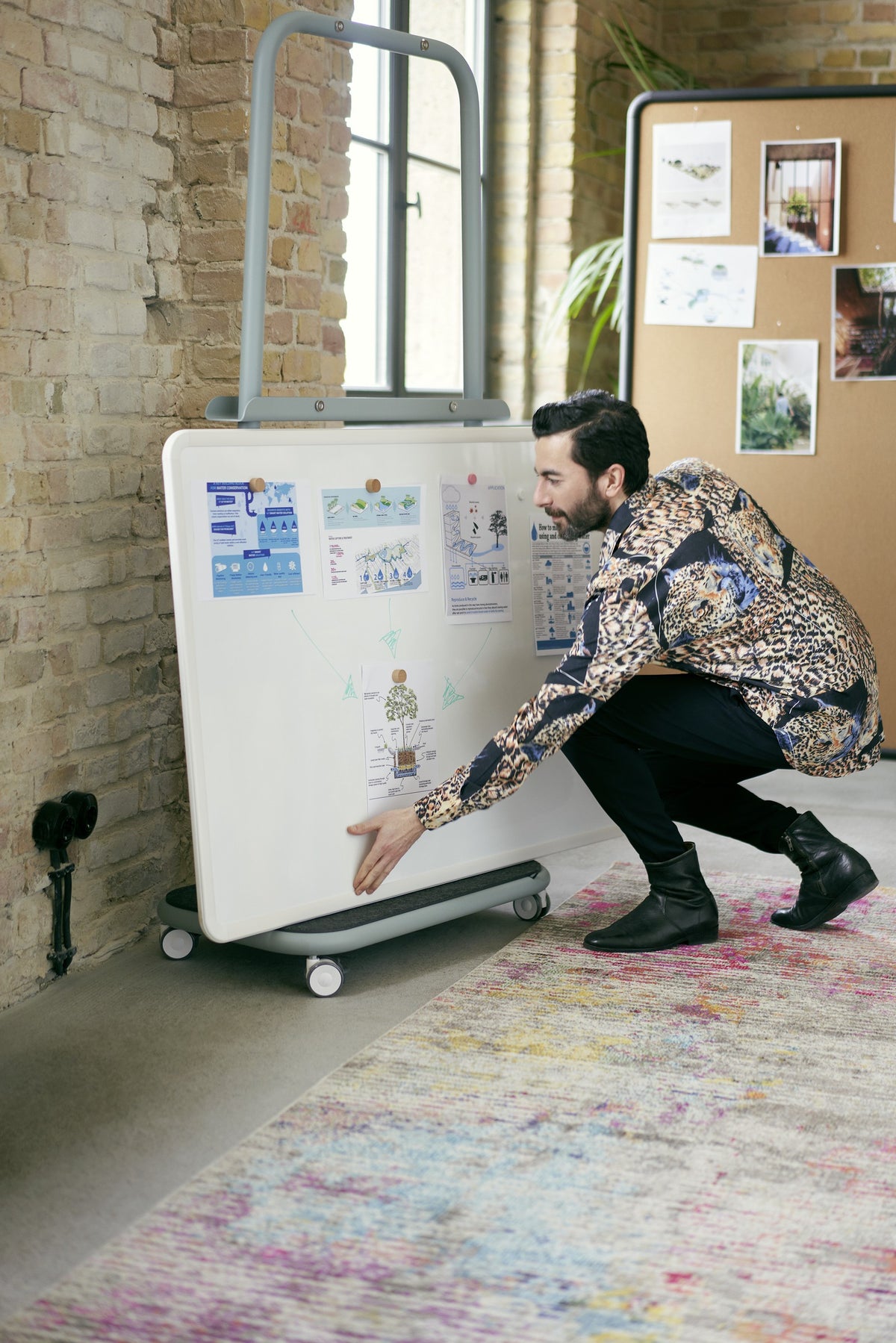 se:lab caddy – Transportwagen von Sedus – Whiteboard wird am Wagen ausgerichtet.