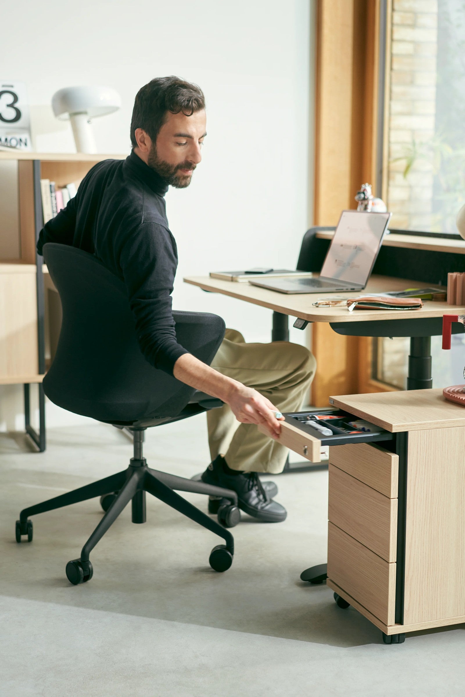 Sedus Rollcontainer am Homeoffice-Platz, Person greift in die Schublade.