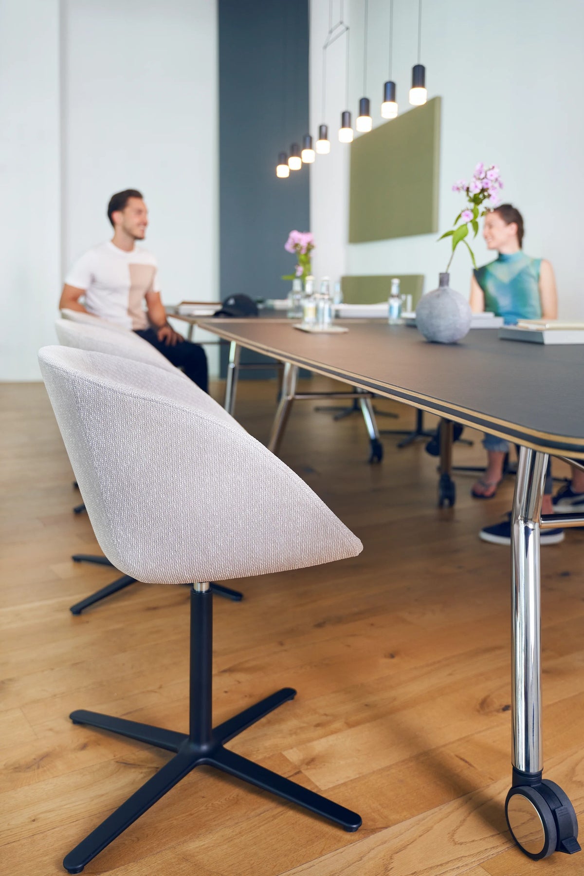 on spot cosy von Sedus in Weiss an einem Meetingtisch mit Rollen am Tisch.